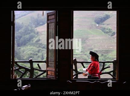 (240715) -- LONGSHENG, 15. Juli 2024 (Xinhua) -- Pan Baofen Braut Tee in der Gastfamilie, die sie im Dorf Dazhai im Bezirk Longsheng, südchinesischer Autonomen Region Guangxi Zhuang betreibt, 26. Juni 2024. Hinter den malerischen Longji Rice Terrassen liegt das Dorf Dazhai, flankiert von üppigem Grün, majestätischen Bergen und einer vielfältigen Auswahl an Gastfamilien. Dieses Dorf wurde von der Welttourismusorganisation (UNWTO) für seine atemberaubende landwirtschaftlich geprägte Aussicht zu den besten Tourismusdörfern des Jahres 2022 ernannt und ist stolz auf seine robusten Gastfamilien, die jährlich mehr als 500.000 Yuan (ca. 68 Yuan) brachten Stockfoto