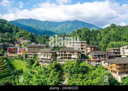 (240715) -- LONGSHENG, 15. Juli 2024 (Xinhua) -- ein Luftdrohnenfoto vom 10. Juli 2024 zeigt Gastfamilien im Dorf Dazhai im County Longsheng, südchinesischer Autonomen Region Guangxi Zhuang. Hinter den malerischen Longji Rice Terrassen liegt das Dorf Dazhai, flankiert von üppigem Grün, majestätischen Bergen und einer vielfältigen Auswahl an Gastfamilien. Dieses Dorf wurde von der Welttourismusorganisation (UNWTO) für seine atemberaubende landwirtschaftlich geprägte Aussicht zu den besten Tourismusdörfern des Jahres 2022 ernannt und ist stolz auf seine robusten Gastfamilien, die jährlich mehr als 500.000 Yuan (ca. 68.854 Yuan) brachten Stockfoto