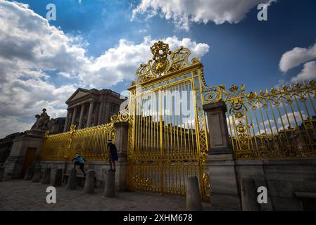 Die verzierten goldenen Tore des Schlosses Versailles mit verspielten Kindern - Versailles, Frankreich Stockfoto