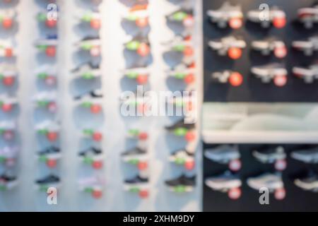 Sneakers werden in Regalen im Sportschuhgeschäft präsentiert und zeigen abstrakten, verschwommenen Hintergrund Stockfoto