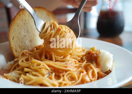 Spaghetti mit Tomatensauce auf einem weißen Teller in einem Restaurant Stockfoto