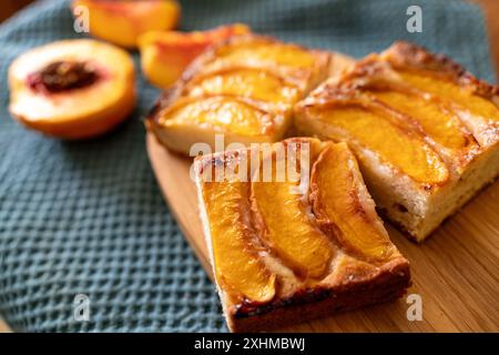 Ein Dessert aus geschnittenen Pfirsichen ist auf einem hölzernen Schneidebrett. Das Dessert ist mit Zucker bedeckt und sieht köstlich aus. Stockfoto
