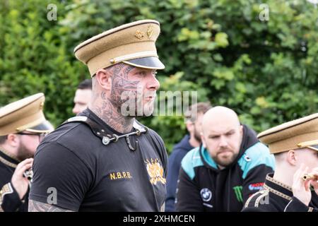 Ballymena, Nordirland - 12. Juli 2024: Orange Order Celebrations, Bassdrummer North Ballymena Protestant Boys mit Tribal Style Tattoos Stockfoto