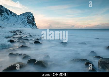 Wellen brechen am verschneiten Unstad Beach, Lofoten Islands, Norwegen Stockfoto