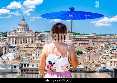 Frau mit Schirm, die von Castel Sant'Angelo aus auf den Vatikan schaut Stockfoto