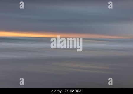 Intention Camera Movement (ICM)-Bild von Strandwellen bei Sonnenuntergang Stockfoto