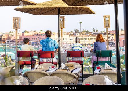 Glückliche Familie mit zwei Jungs, die Marrakesch bewunderten, die auf einer Sky Bar sitzen Stockfoto