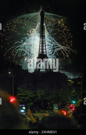 Paris, Frankreich, 14. Juli 2024. Riesiges Feuerwerk am Eiffelturm mit Menschen und Autos auf den Straßen Credit: Jacques Julien/Alamy Live News Stockfoto