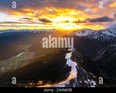 Aus der Vogelperspektive auf das Valtellina und die schneebedeckten Gipfel bei Sonnenuntergang im Herbst, Italien Stockfoto