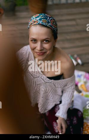 Frau Künstlerin malt auf Leinwand, Ölfarben. Staffelei auf Terrasse, Sommer. Stockfoto