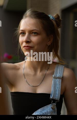 Frau Künstlerin malt auf Leinwand, Ölfarben. Staffelei auf Terrasse, Sommer. Stockfoto