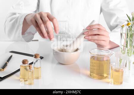Aromatherapeutikum. Wissenschaftler, der ätherische Öle am weißen Tisch im Labor entwickelt, Nahaufnahme Stockfoto