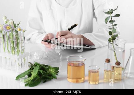 Aromatherapeutikum. Wissenschaftler, der ätherische Öle am weißen Tisch im Labor entwickelt, Nahaufnahme Stockfoto