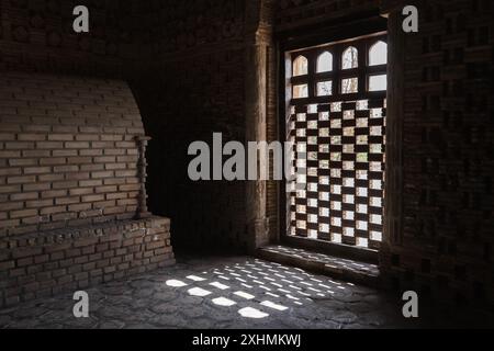 Samanid Mausoleum, dunkles Interieur mit einer Tür. Es wurde im 10. Jahrhundert n. Chr. in Buchara, Usbekistan, erbaut Stockfoto