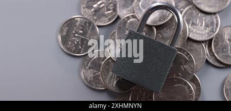 Nahaufnahme des Vorhängeschlosses auf Münzen, finanzielle Sicherheit und Schutzfinanzierung. Sparen Sie an einem sicheren Ort. Bewahren Sie Geldeinsparungen an einem sicheren Ort auf Stockfoto