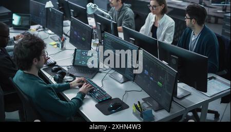 Verschiedene Softwareentwicklungsabteilung, die an einem Werkzeug für künstliche Intelligenz arbeitet und Programmiercode schreibt. Gruppe von Cyber Security Engineers, die einen neuen Cloud-basierten Service integrieren Stockfoto