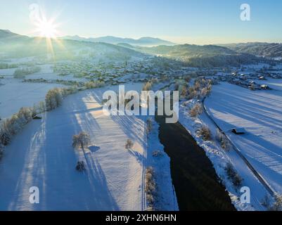 Luftaufnahme eines Flusses und Dorfes vor den Bergen, Winter, Abendlicht, Schlehdorf, Loisach, Blick nach Großweil, Bayern, Deutschland, Europa Stockfoto