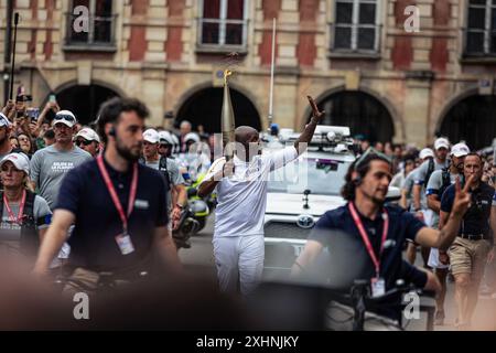 Paris, Frankreich. Juli 2024. Ein olympischer Fackelträger passiert vor dem Maison Victor Hugo auf dem Place des Vosges. Am Tag der Bastille-Feierlichkeiten erhielt Paris die olympische Flamme. Der erste von zwei Tagen der Reise der Olympischen Flamme in Paris begann auf der Champs-Elysées Avenue, vorbei an emblematischen Sehenswürdigkeiten in der französischen Hauptstadt, wie der Kathedrale Notre-Dame, und endete am Hotel de Ville. Quelle: SOPA Images Limited/Alamy Live News Stockfoto