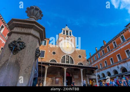 Venedig, Italien - 03. Juni 2024: Trinkbrunnen in der Straße Ruga dei Oresi. Chiesa di San Giacomo di Rialto im Hintergrund. Sonniger Tag, klarer Himmel. Stockfoto