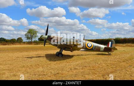 Vintage Spitfire BM597 (G-MKVB) Mk. VB statisch auf der Landebahn mit blauem Himmel und Wolken. Stockfoto