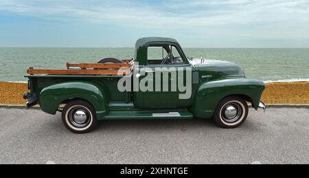 Klassischer Chevrolet Pick-up-Truck, der an der Strandpromenade und am Meer im Hintergrund geparkt ist. Stockfoto