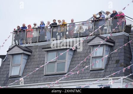 Die Leute warten vom Royal Yacht Hotel auf die Ankunft von König Charles III. Und Königin Camilla, um während ihres zweitägigen Besuchs auf den Kanalinseln am Weighbridge Place in St. Helier, Jersey, am Jersey Expo Event teilzunehmen. Bilddatum: Montag, 15. Juli 2024. Stockfoto