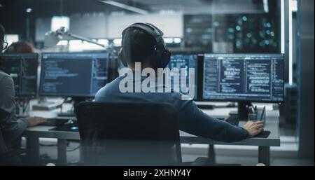 Gruppe von befähigten multikulturellen Männern und Frauen, die in einem Forschungszentrum arbeiten und Computer verwenden, um fortgeschrittene Software auszuführen und eine Schnittstelle für künstliche Intelligenz zu entwickeln Stockfoto