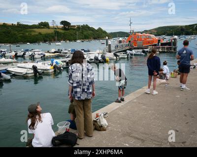 Familienlustige genießen Krabbenfischen am Pier in Salcombe, South Hams, Devon, Großbritannien Stockfoto