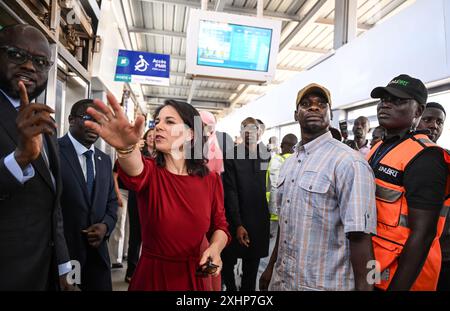 Dakar, Senegal. Juli 2024. Annalena Baerbock (Allianz 90/die Grünen) steht bei einem Besuch zusammen mit dem senegalesischen Infrastrukturminister Malick Ndiaye (l) an einer Bushaltestelle des Bus Rapid Transit (BRT). Die Reise konzentriert sich auf Bemühungen, die Sahelzone zu stabilisieren. Quelle: Britta Pedersen/dpa/Alamy Live News Stockfoto