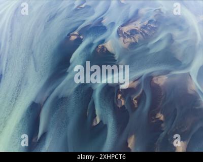 Blick von oben auf atemberaubende Muster im vulkanischen Sand Islands. Wenn Gletscher schmelzen, fließt das Wasser als Flüsse ins Meer. Stockfoto