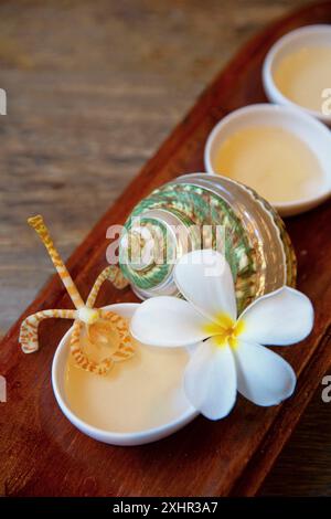 Französisch-Polynesien, Insel Taha'a, Holztablett mit kleinen Schüsseln gefüllt mit monoi, einer Tiareblume und einer Orchidee im Spa des Taha'a by Pear Stockfoto