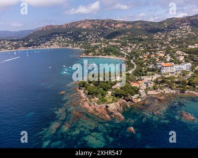 Panoramablick von oben auf das blaue Mittelmeer dea, Sandstrand der Stadt Agay, Sommerferienziel in der Nähe der roten Berge von Esterel, französische Riviera, Stockfoto