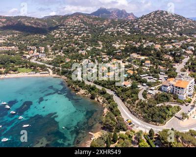 Panoramablick von oben auf das blaue Mittelmeer dea, Sandstrand der Stadt Agay, Sommerferienziel in der Nähe der roten Berge von Esterel, französische Riviera, Stockfoto