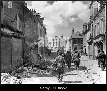 2. Weltkrieg 1944 D-DAY amerikanische Truppen durchqueren die Normandie Frankreich nach der ersten Invasion am 6. Juni 1944 auf der Suche nach Taschen des Widerstands der Nazi-Wehrmacht 2. Weltkrieg die Schlacht von Carentan war ein Gefecht im Zweiten Weltkrieg zwischen der US-Armee und der deutschen Wehrmacht während der Schlacht in der Normandie. Die Schlacht fand zwischen dem 6. Und 13. Juni 1944 in Carentan, Frankreich, statt. Das Ziel der angreifenden amerikanischen Streitkräfte war die Konsolidierung der US-Strangköpfe (Utah Beach und Omaha Beach) und die Errichtung einer kontinuierlichen Verteidigung. Normandie Frankreich Stockfoto