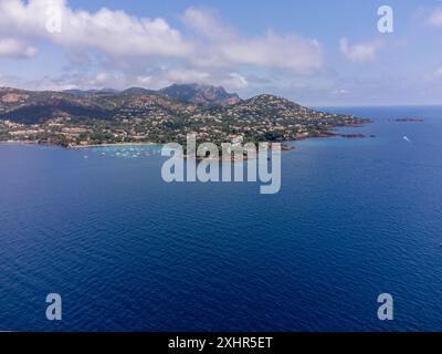 Panoramablick von oben auf das blaue Mittelmeer dea, Sandstrand der Stadt Agay, Sommerferienziel in der Nähe der roten Berge von Esterel, französische Riviera, Stockfoto