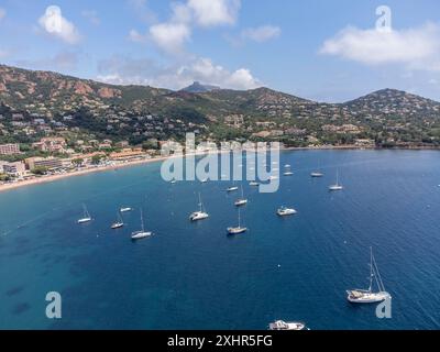 Panoramablick von oben auf das blaue Mittelmeer dea, Sandstrand der Stadt Agay, Sommerferienziel in der Nähe der roten Berge von Esterel, französische Riviera, Stockfoto