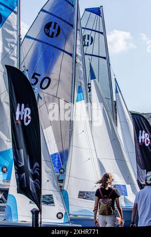 Zwei Personen, ein Mann, eine Frau, die an den Segeln vorbeiläuft, die im Wind wehen. Stockfoto