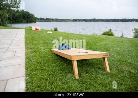 Das Maisloch-Spiel wird auf Gras in der Nähe des Seeufers organisiert. Stockfoto