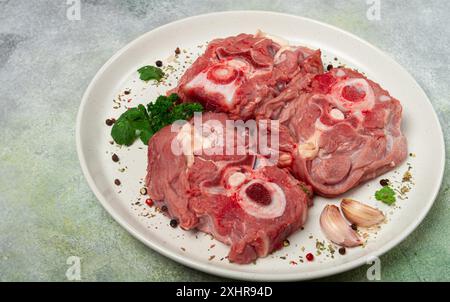 Rohes Steak, Kalbhals auf den Knochen, frisches Fleisch, auf einem weißen Teller, Blick von oben, keine Leute Stockfoto