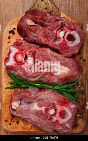 Rohes Steak, Kalbhals auf den Knochen, frisches Fleisch, auf dem Schneidebrett, Blick von oben, keine Leute Stockfoto