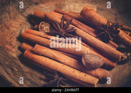 Zimtstangen, mit Muskatnuss und Anisstern, auf einem Holzteller, Draufsicht, keine Leute Stockfoto