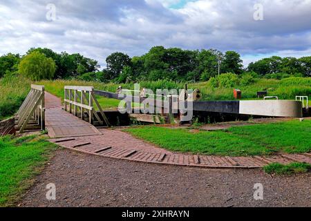 Das Monument Lock Tore und kleine weiße Holzbrücke, der Kennett & Avon Canal bei Devizes. Vom Juli 2024. Sommer. Stockfoto