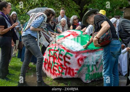 Detroit, Michigan, USA. Juli 2024. Interreligiöse Führer versammelten sich an der Wayne State University, um sich zu versammeln und für Frieden in Gaza zu beten. Sie baten die Universität, sich von Unternehmen zu veräußern, die von Krieg und Waffenherstellung profitieren. Die Universität schaltete Rasensprenger rund um Spirit Rock ein, wo sie sich sammeln wollten. Spirit Rock war der Ort eines Antikriegslagers für Studenten, das die Universitätspolizei im Mai abbrach. Quelle: Jim West/Alamy Live News Stockfoto