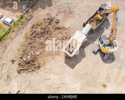 Luftaufnahme eines Baggers in der Nähe von Holzabfällen auf einer Baustelle, Abbruchstelle, Recycling, Saarbrücken, Deutschland Stockfoto