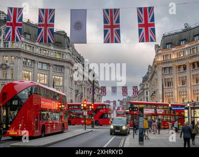 Rote Doppeldeckerbusse, englische Flaggen, Abendstimmung, Oxford Circus, London, London Region, England, Großbritannien Stockfoto