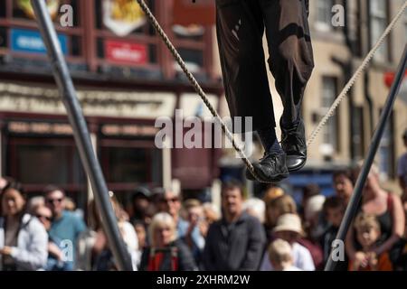 Die Füße balancieren am Seil, Straßenkünstler und Zuschauer bei einer Hochseilakrobatik-Performance, dem weltweit größten Kulturfestival The Fringe, High Stockfoto