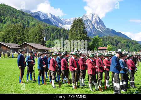 Männer in historischen Uniformen stehen auf einem grünen Feld vor der Kulisse der Alpen, Garmisch-Partenkirchen, Alpentreffen, Bayern, Tirol Stockfoto