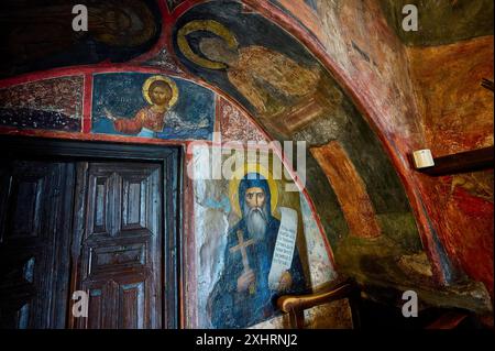 Szene einer orthodoxen Kirche mit religiösen Wandmalereien und einer Holztür im Hintergrund, im Kloster Agiou Theologou Stockfoto