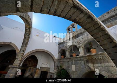 Historischer Klosterhof mit Steinbögen, einem Turm und hängenden Pflanzen. Beeindruckende architektonische Details unter einem blauen Himmel im Inneren des Klosters Stockfoto