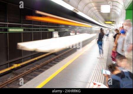 Konzeptionelles Bild des U-Bahn-Bahnsteigs. Eine Lichtspur auf den Gleisen erinnert an die Passage des Zuges, die Figuren auf dem Bahnsteig deuten darauf hin, dass die Menschen das tun Stockfoto